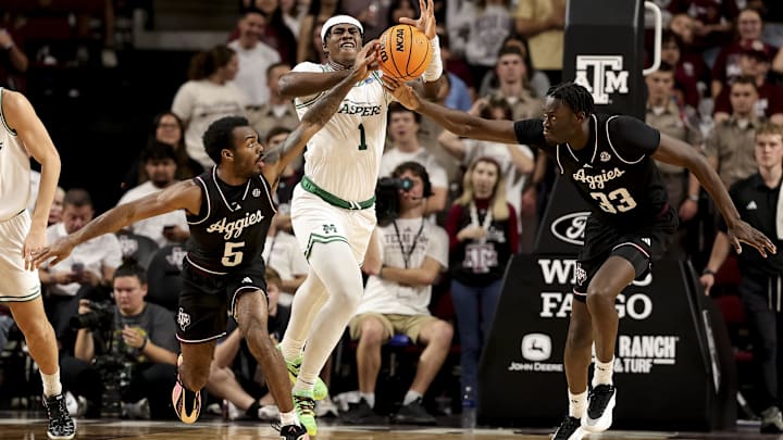 Nov 21, 2025; College Station, Texas, USA; Manhattan Jaspers forward Anthony Isaac (1) and Texas A&M Aggies center Federiko Federiko (33) and guard Jacari Lane (5) battle for a rebound during the second half at Reed Arena. Mandatory Credit: Maria Lysaker-Imagn Images 
