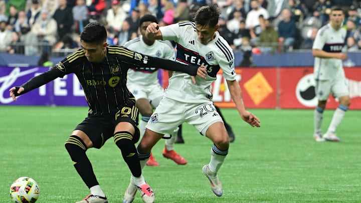 Nov 3, 2024; Vancouver, British Columbia, CAN; LAFC midfielder Eduard Atuesta (20) plays the ball with Vancouver Whitecaps midfielder Andrés Cubas (20) in the second half in a 2024 MLS Cup Playoffs Round One match at BC Place. Mandatory Credit: Anne-Marie Sorvin-Imagn Images