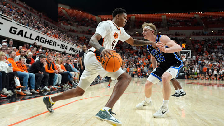 Oklahoma State Cowboys guard Christian Coleman (4) dribbles beside BYU Cougars guard Richie Saunders (15) during a BIG 12 men's college basketball game between the Oklahoma State Cowboys (OSU) and the BYU Cougars at Gallagher-Iba Arena in Stillwater, Okla., Wednesday, Feb. 4, 2026.