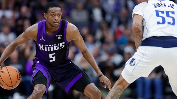 Mar 26, 2024; Sacramento, California, USA; Sacramento Kings guard De'Aaron Fox (5) dribbles the ball against Dallas Mavericks forward Derrick Jones Jr. (55) during the third quarter at Golden 1 Center. 