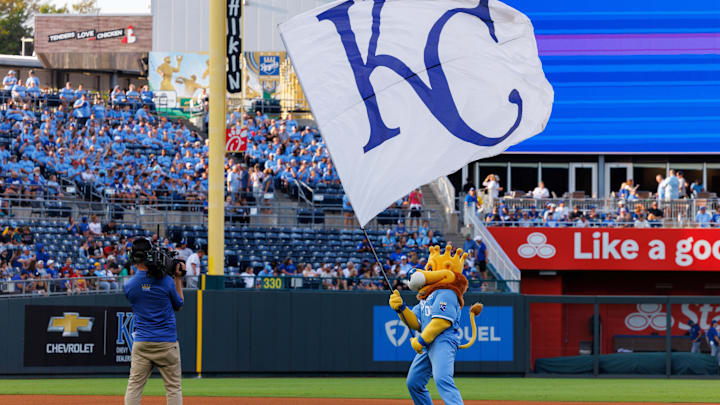 Sep 20, 2025; Kansas City, Missouri, USA; Kansas City Royals mascot Slugger waves the KC flag prior to the game against the Toronto Blue Jays at Kauffman Stadium. Mandatory Credit: William Purnell-Imagn Images Sep 20, 2025; Kansas City, Missouri, USA; Kansas City Royals mascot Slugger waves the KC flag prior to the game against the Toronto Blue Jays at Kauffman Stadium. Mandatory Credit: William Purnell-Imagn Images