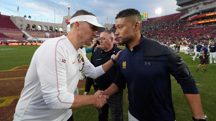 Nov 30, 2024; Los Angeles, California, USA; Southern California Trojans head coach Lincoln Riley and Notre Dame Fighting Irish head coach Marcus Freeman shake hands after the game at United Airlines Field at Los Angeles Memorial Coliseum. Mandatory Credit: Kirby Lee-Imagn Images Nov 30, 2024; Los Angeles, California, USA; Southern California Trojans head coach Lincoln Riley and Notre Dame Fighting Irish head coach Marcus Freeman shake hands after the game at United Airlines Field at Los Angeles Memorial Coliseum. Mandatory Credit: Kirby Lee-Imagn Images