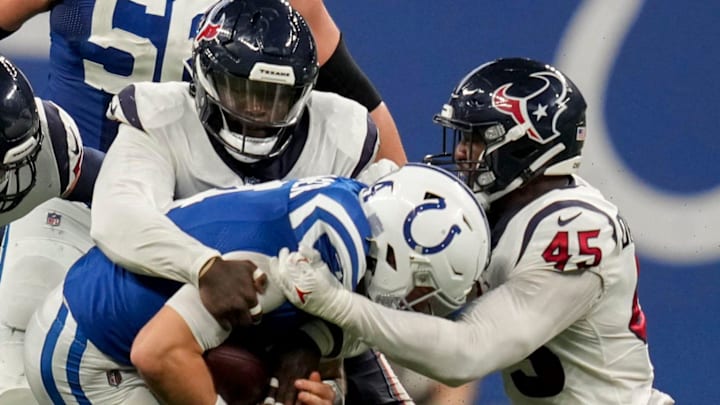 Houston Texans defenders, including linebacker Ogbonnia Okoronkwo (45), work to bring down Indianapolis Colts quarterback Sam Ehlinger (4) on Jan. 8, 2023.