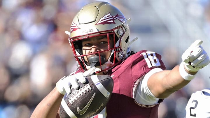Nov 23, 2024; Tallahassee, Florida, USA; Florida State Seminoles tight end Landen Thomas (18) celebrates a first down grab as Charleston Southern Buccaneers safety Davion Williams (2) looks on during the second half of the game at Doak S. Campbell Stadium. Mandatory Credit: Melina Myers-Imagn Images