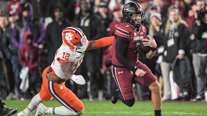 Nov 25, 2023; Columbia, South Carolina, USA; South Carolina Gamecocks quarterback Spencer Rattler (7) runs the ball against Clemson Tigers defensive lineman T.J. Parker (12) during the first quarter at Williams-Brice Stadium. Mandatory Credit: Ken Ruinard-Imagn Images