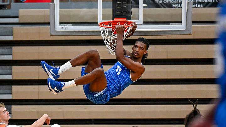 Team LAFCU and Michigan State's Ethan Taylor hangs on the rim after a dunk against Team Tri-Star during the Moneyball Pro-Am on Tuesday, June 23, 2026, at Holt High School.