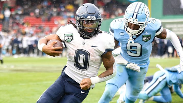 Connecticut's Cam Edwards carries the ball, defended by North Carolina's Tyrane Stewart during the third annual Fenway Bowl at Fenway Park on Saturday, Dec. 28, 2024. USA TODAY NETWORK