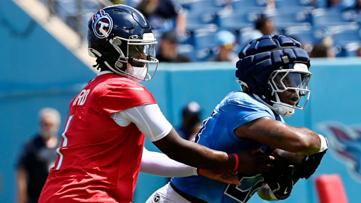 Tennessee Titans quarterback Cam Ward (1) hands the ball off to running back Kalel Mullings (28) during “Back Together Weekend” training camp practice at Nissan Stadium Saturday, July 26, 2025, in Nashville, Tenn.