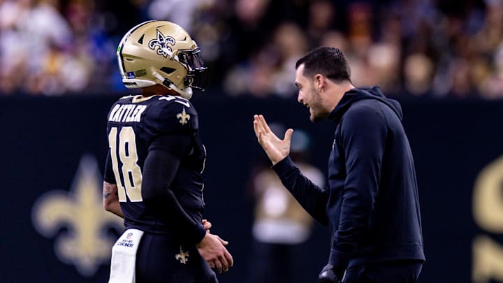Dec 15, 2024; New Orleans, Louisiana, USA;  New Orleans Saints quarterback Derek Carr (4) jokes with quarterback Spencer Rattler (18) after a touchdown against the Washington Commanders during the second half at Caesars Superdome. Mandatory Credit: Stephen Lew-Imagn Images