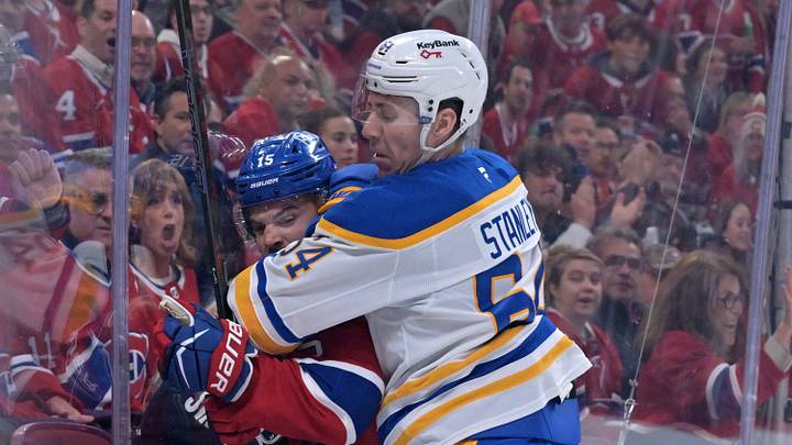 May 10, 2026; Montreal, Quebec, CAN; Buffalo Sabres defenseman Logan Stanley (64) checks Montreal Canadiens forward Alex Newhook (15) during the first period in game three of the second round of the 2026 Stanley Cup Playoffs at the Bell Centre. Mandatory Credit: Eric Bolte-Imagn Images