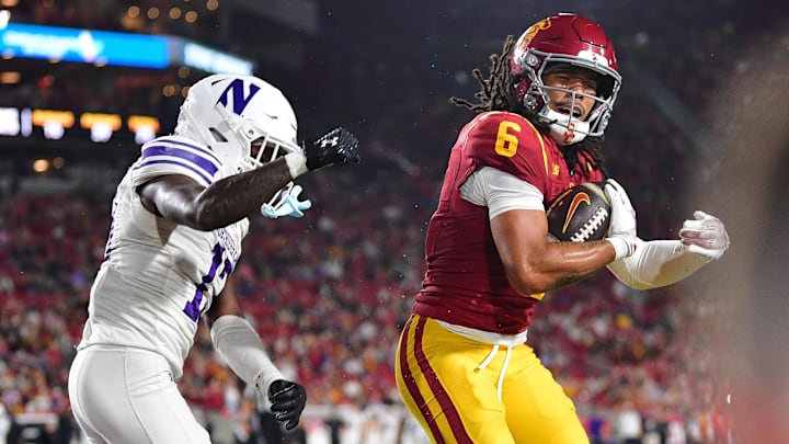 Nov 7, 2025; Los Angeles, California, USA; Southern California Trojans wide receiver Makai Lemon (6) scores a touchdown against Northwestern Wildcats defensive back Josh Fussell (13) during the first half at the Los Angeles Memorial Coliseum. Mandatory Credit: Gary A. Vasquez-Imagn Images