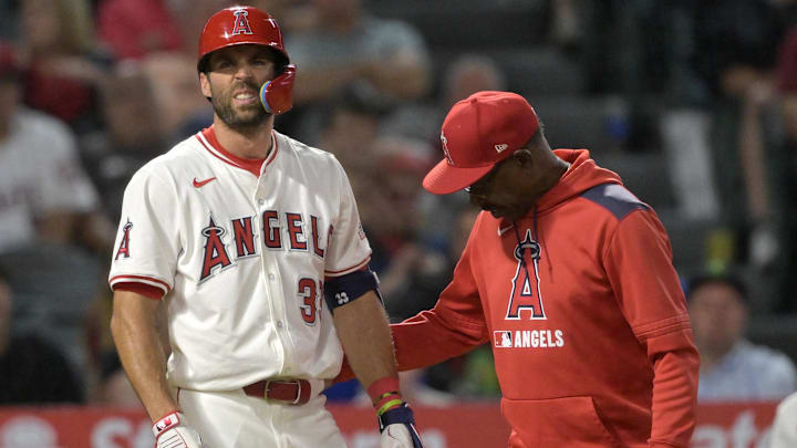 Jun 9, 2025; Anaheim, California, USA;  Los Angeles Angels manager Ron Washington (37) checks on center fielder Chris Taylor (33) after he was hit by a pitch left hand in the eighth inning against the Athletics at Angel Stadium. Taylor was diagnosed with a fracture in the hand. Mandatory Credit: Jayne Kamin-Oncea-Imagn Images