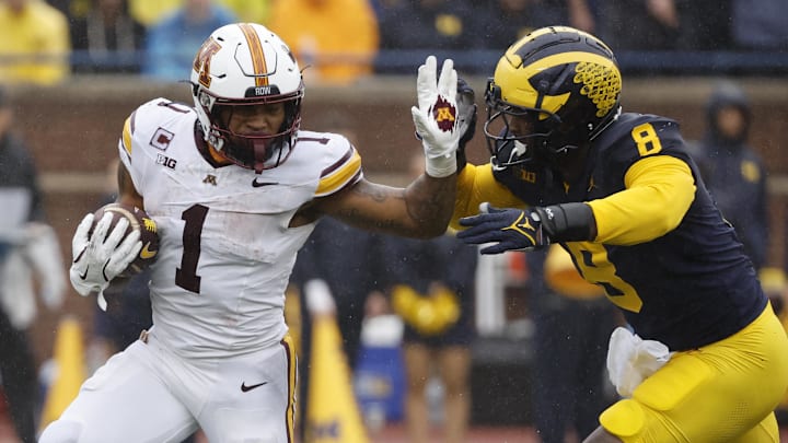 Sep 28, 2024; Ann Arbor, Michigan, USA; Minnesota Golden Gophers running back Darius Taylor (1) rushes chased by Michigan Wolverines defensive end Derrick Moore (8) in the first half at Michigan Stadium. Sep 28, 2024; Ann Arbor, Michigan, USA; Minnesota Golden Gophers running back Darius Taylor (1) rushes chased by Michigan Wolverines defensive end Derrick Moore (8) in the first half at Michigan Stadium.