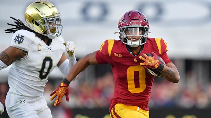 Nov 30, 2024; Los Angeles, California, USA; Southern California Trojans running back Quinten Joyner (0) runs the ball ahead of Notre Dame Fighting Irish safety Xavier Watts (0) during the second half at the Los Angeles Memorial Coliseum. 