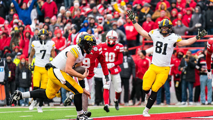 Nov 28, 2025; Lincoln, Nebraska, USA; Iowa Hawkeyes quarterback Mark Gronowski (11) scores a touchdown as tight end DJ Vonnahme (81) celebrates during the fourth quarter against the Nebraska Cornhuskers at Memorial Stadium. Mandatory Credit: Dylan Widger-Imagn Images