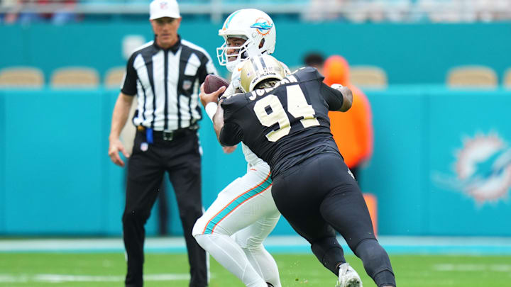 Nov 30, 2025; Miami Gardens, Florida, USA; New Orleans Saints defensive end Cameron Jordan (94) applies pressure on Miami Dolphins quarterback Tua Tagovailoa (1) during the first half at Hard Rock Stadium. Mandatory Credit: Rich Storry-Imagn Images