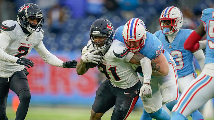 Tennessee Titans defensive tackle James Lynch (97) tackles Houston Texans running back Dameon Pierce (31) during the fourth quarter at Nissan Stadium in Nashville, Tenn., Sunday, Jan. 5, 2025.
