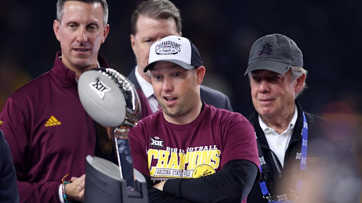 Dec 7, 2024; Arlington, TX, USA; Arizona State Sun Devils head coach Kenny Dillingham looks at the trophy after winning the Big 12 Championship game against the Iowa State Cyclones at AT&T Stadium. Mandatory Credit: Tim Heitman-Imagn Images