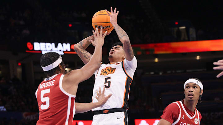 Oklahoma State guard Vyctorius Miller, center, shoots between Oklahoma forward Mohamed Wague, left, and forward Tae Davis (13) during the first half of a Bedlam men's college basketball game between the OSU Cowboys and OU Sooners at Paycom Center in Oklahoma City, Saturday, Dec. 13, 2025. Oklahoma State guard Vyctorius Miller, center, shoots between Oklahoma forward Mohamed Wague, left, and forward Tae Davis (13) during the first half of a Bedlam men's college basketball game between the OSU Cowboys and OU Sooners at Paycom Center in Oklahoma City, Saturday, Dec. 13, 2025.
