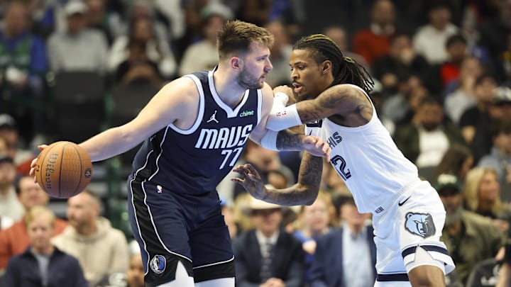 Dec 3, 2024; Dallas, Texas, USA;  Dallas Mavericks guard Luka Doncic (77) controls the ball as Memphis Grizzlies guard Ja Morant (12) defends during the second half at American Airlines Center. Mandatory Credit: Kevin Jairaj-Imagn Images