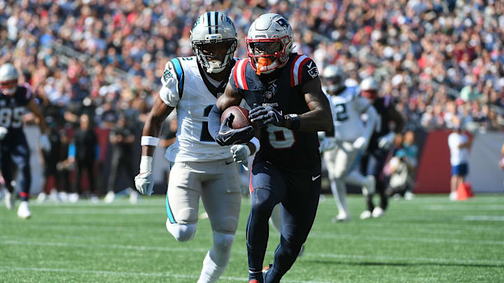 Sep 28, 2025; Foxborough, Massachusetts, USA; New England Patriots wide receiver Stefon Diggs (8) runs with the ball while Carolina Panthers cornerback Mike Jackson (2) defends during the first half at Gillette Stadium. Mandatory Credit: Bob DeChiara-Imagn Images