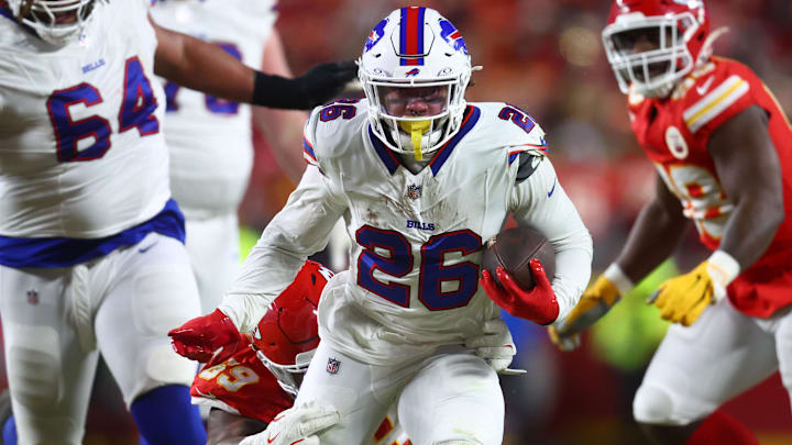 Jan 26, 2025; Kansas City, MO, USA; Buffalo Bills running back Ty Johnson (26) rushes the ball past Kansas City Chiefs defensive tackle Mike Pennel Jr. (69) during the second half in the AFC Championship game at GEHA Field at Arrowhead Stadium. 