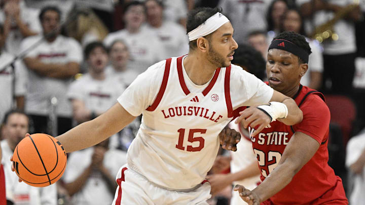 Feb 9, 2026; Louisville, Kentucky, USA;  Louisville Cardinals center Aly Khalifa (15) looks to pass against NC State Wolfpack forward Ven-Allen Lubin (22) during the first half at KFC Yum! Center. Louisville defeated N.C. State 118-77. Mandatory Credit: Jamie Rhodes-Imagn Images