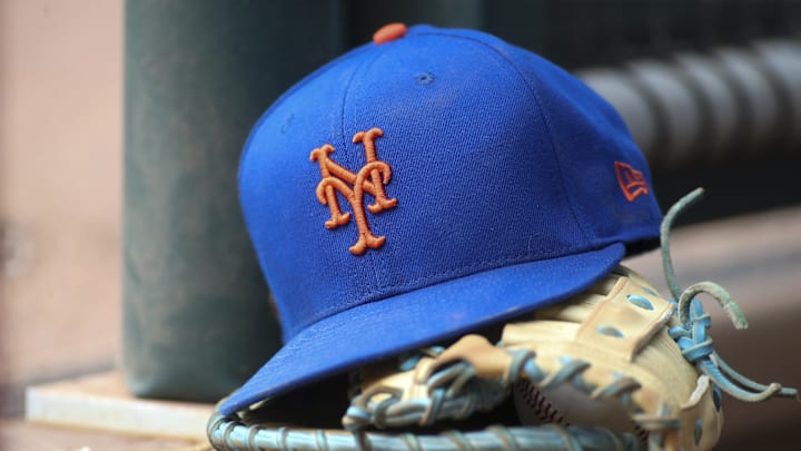 Jul 13, 2022; Atlanta, Georgia, USA; A detailed view of a New York Mets hat and glove in the dugout against the Atlanta Braves in the eighth inning at Truist Park. Mandatory Credit: Brett Davis-Imagn Images