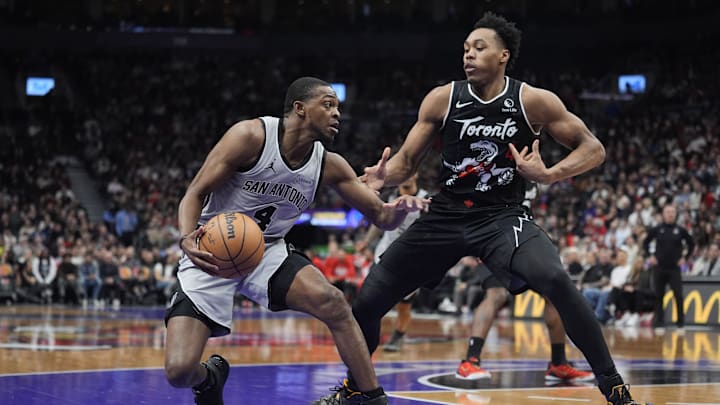 Feb 25, 2026; Toronto, Ontario, CAN; San Antonio Spurs guard De'Aaron Fox (4) controls the ball against Toronto Raptors guard Scottie Barnes (4) during the first half at Scotiabank Arena. Mandatory Credit: John E. Sokolowski-Imagn Images