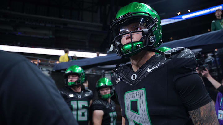 Dec 7, 2024; Indianapolis, IN, USA; Oregon Ducks quarterback Dillon Gabriel (8) runs out for warmups against the Penn State Nittany Lions in the 2024 Big Ten Championship game at Lucas Oil Stadium. Mandatory Credit: Robert Goddin-Imagn Images