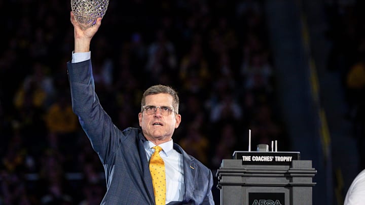 Michigan head coach Jim Harbaugh lifts the AFCA Coaches' Trophy during the national championship