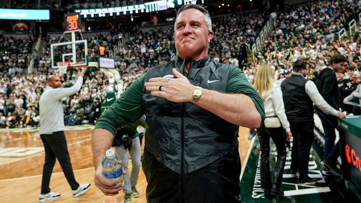 Michigan State's new football coach Pat Fitzgerald pats his heart at the crowd in attendance for the Spartans basketball game against Iowa on Tuesday, Dec. 2, 2025, at the Breslin Center in East Lansing.