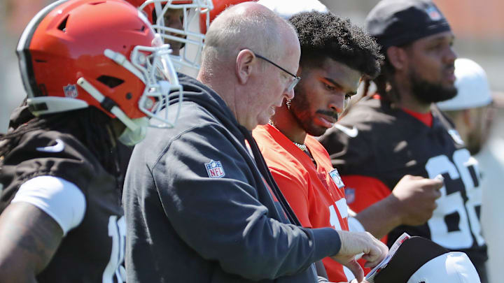 Cleveland Browns quarterbacks coach Bill Musgrave, left, works with quarterback Shedeur Sanders (12) during NFL rookie minicamp at the Cleveland Browns training facility on Friday, May 9, 2025, in Berea, Ohio.