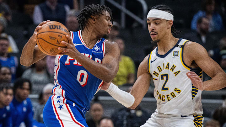 Jan 25, 2024; Indianapolis, Indiana, USA; Philadelphia 76ers guard Tyrese Maxey (0) drives to the basket while Indiana Pacers guard Andrew Nembhard (2) defends in the first half at Gainbridge Fieldhouse. Mandatory Credit: Trevor Ruszkowski-Imagn Images