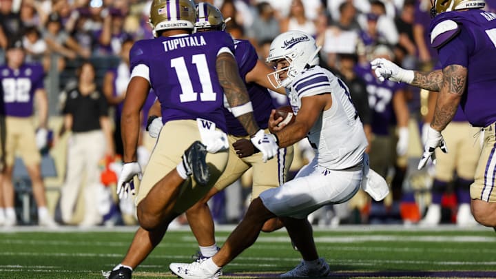 Sep 21, 2024; Seattle, Washington, USA; Northwestern Wildcats quarterback Jack Lausch (12) rushes against the Washington Huskies during the second quarter at Alaska Airlines Field at Husky Stadium. Mandatory Credit: Joe Nicholson-Imagn Images