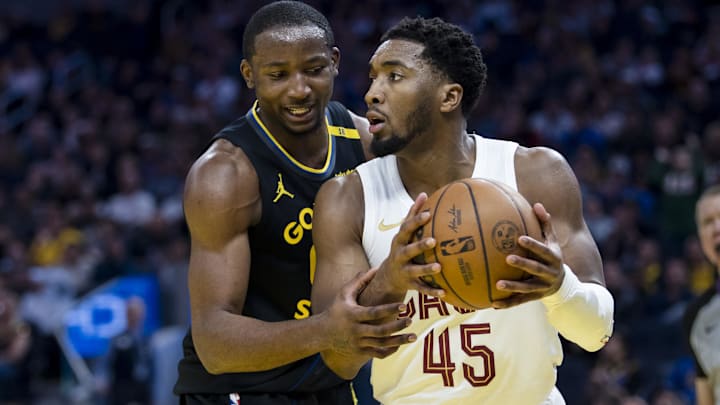 Dec 30, 2024; San Francisco, California, USA; Golden State Warriors forward Jonathan Kuminga (00) defends against Cleveland Cavaliers guard Donovan Mitchell (45) during the third quarter at Chase Center. Mandatory Credit: John Hefti-Imagn Images