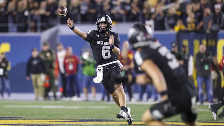 Oct 12, 2024; Morgantown, West Virginia, USA; West Virginia Mountaineers quarterback Garrett Greene (6) throws a pass against the Iowa State Cyclones during the first quarter at Mountaineer Field at Milan Puskar Stadium. Mandatory Credit: Ben Queen-Imagn Images