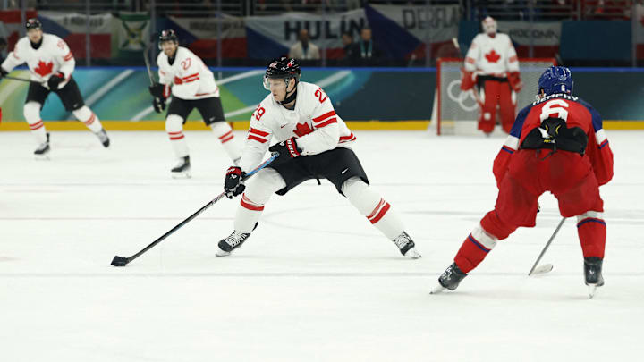 Feb 12, 2026; Milan, Italy; Nathan Mackinnon of Canada in action with Michal Kempny of Czechia in a men's ice hockey group A match during the Milano Cortina 2026 Olympic Winter Games at Milano Santagiulia Ice Hockey Arena. Mandatory Credit: Geoff Burke-Imagn Images