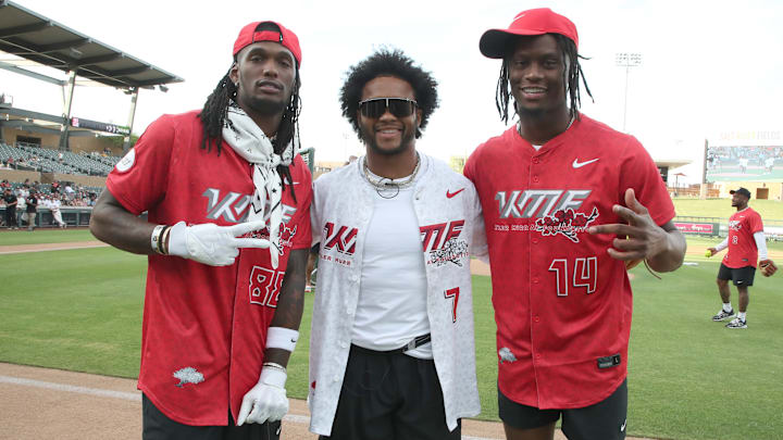 Cowboys WRs CeeDee Lamb (L) and George Pickens (R) pose with Cardinals QB Kyler Murray at Murray's charity softball event