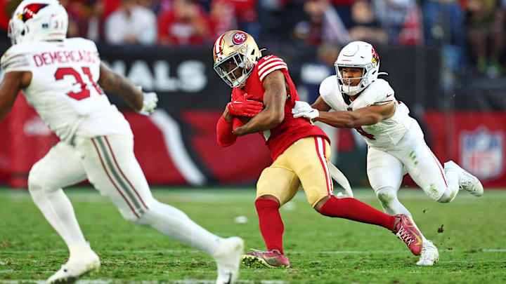 Dec 17, 2023; Glendale, Arizona, USA; San Francisco 49ers cornerback Charvarius Ward (7) runs the ball after an interception against Arizona Cardinals wide receiver Rondale Moore (4) at State Farm Stadium. Mandatory Credit: Mark J. Rebilas-Imagn Images