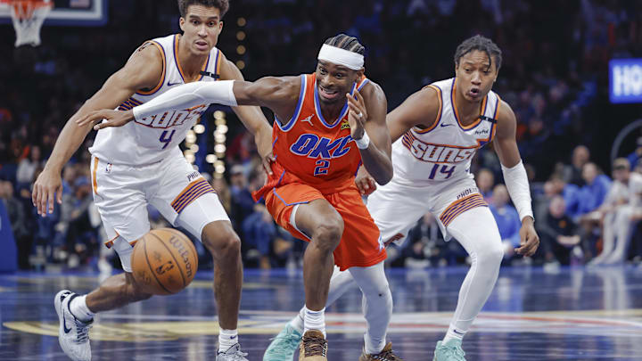 Nov 15, 2024; Oklahoma City, Oklahoma, USA; Oklahoma City Thunder guard Shai Gilgeous-Alexander (2), Phoenix Suns center Oso Ighodaro (4) and guard TyTy Washington Jr. (14) chase after a loose ball during the fourth quarter at Paycom Center. Mandatory Credit: Alonzo Adams-Imagn Images