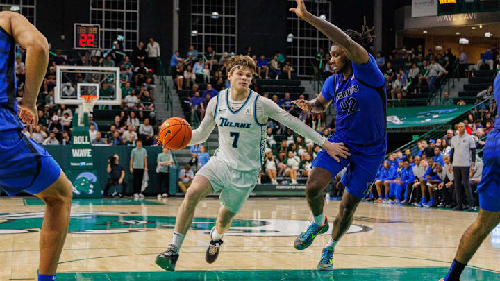 Jan 30, 2025; New Orleans, Louisiana, USA; Tulane Green Wave guard Rowan Brumbaugh (7) drives to the basket against Memphis Tigers forward Dain Dainja (42) during the second half at Avron B. Fogelman Arena in Devlin Fieldhouse. Mandatory Credit: Stephen Lew-Imagn Images