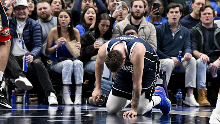 Feb 2, 2023; Dallas, Texas, USA; Dallas Mavericks guard Luka Doncic (77) kneels on the floor after he is fouled by New Orleans Pelicans forward Brandon Ingram (not pictured) as he drives to the basket during the second half at the American Airlines Center. Mandatory Credit: Jerome Miron-Imagn Images