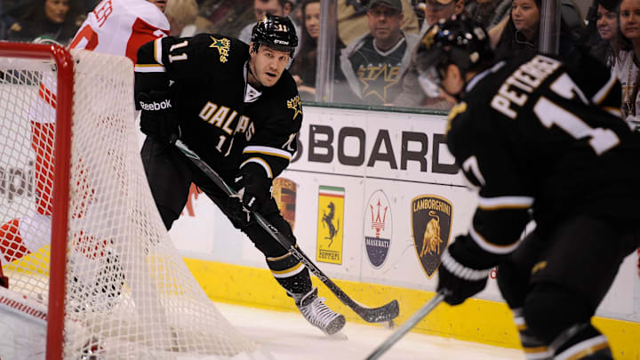 Jan 17, 2012; Dallas, TX, USA;  Dallas Stars center Jake Dowell (11) passes the puck to center Toby Petersen (17) as Detroit Red Wings left wing Drew Miller (20) defends during the second period at the American Airlines Center. Mandatory Credit: Jerome Miron-Imagn Images