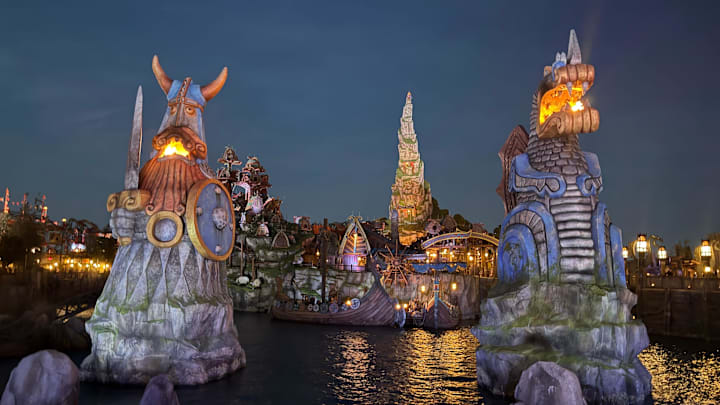 Fires glow in Universal Epic Universe's How to Train Your Dragon – Isle of Berk at night.