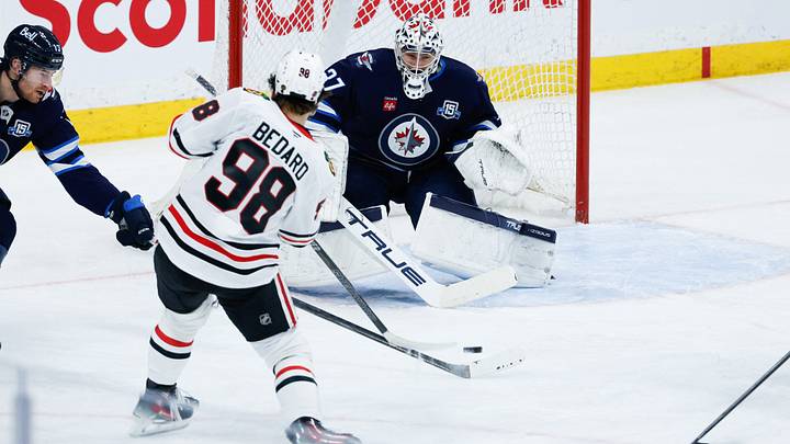 Mar 3, 2026; Winnipeg, Manitoba, CAN;  Winnipeg Jets goalie Connor Hellebuyck (37) makes a save against Chicago Blackhawks forward Connor Bedard (98) during the second period at Canada Life Centre. Mandatory Credit: Terrence Lee-Imagn Images