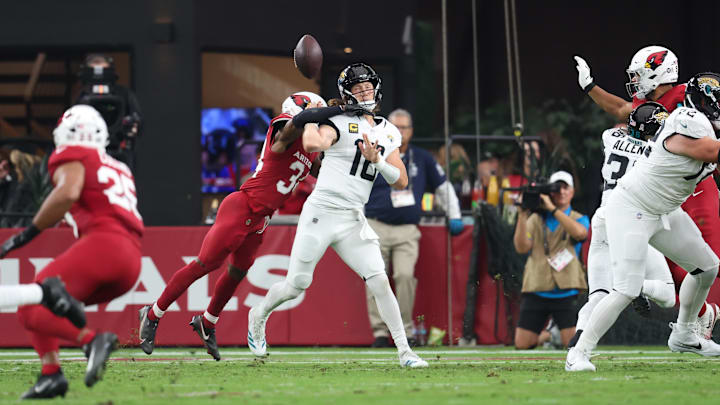 Nov 23, 2025; Glendale, Arizona, USA; Arizona Cardinals safety Jalen Thompson (34) forces a fumble from Jacksonville Jaguars quarterback Trevor Lawrence (16) during the first quarter at State Farm Stadium. Mandatory Credit: Mark J. Rebilas-Imagn Images