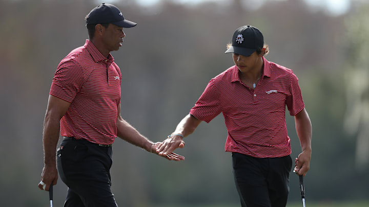 Tiger Woods and son Charlie Woods celebrate after a putt on the ninth green during the PNC Championship at The Ritz-Carlton Golf Club.