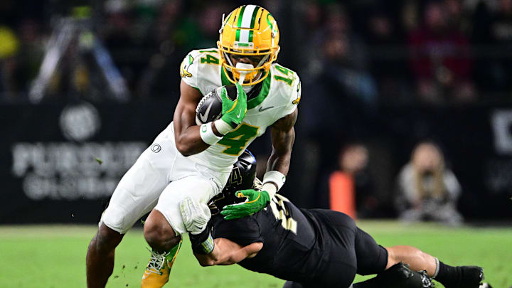 Oct 18, 2024; West Lafayette, Indiana, USA; Oregon Ducks wide receiver Justius Lowe (14) is tackled by Purdue Boilermakers linebacker Yanni Karlaftis (14) during the second half at Ross-Ade Stadium. Mandatory Credit: Marc Lebryk-Imagn Images