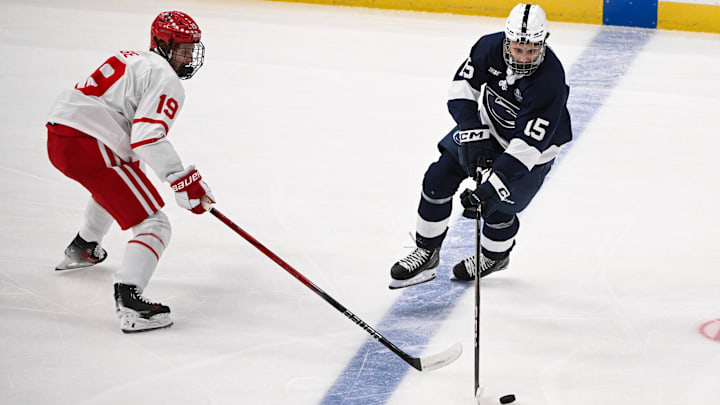 Apr 10, 2025; St. Louis, Missouri, UNITED STATES; Penn State Nittany Lions forward Charlie Cerrato (15) controls the puck while Boston University Terriers defenseman Jack Page (19) defends during the first period of the Frozen Four college ice hockey national semifinals at Enterprise Center. Mandatory Credit: Connor Hamilton-Imagn Images